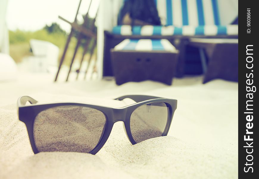 Black sunglasses on sandy beach in tropical resort. Black sunglasses on sandy beach in tropical resort.