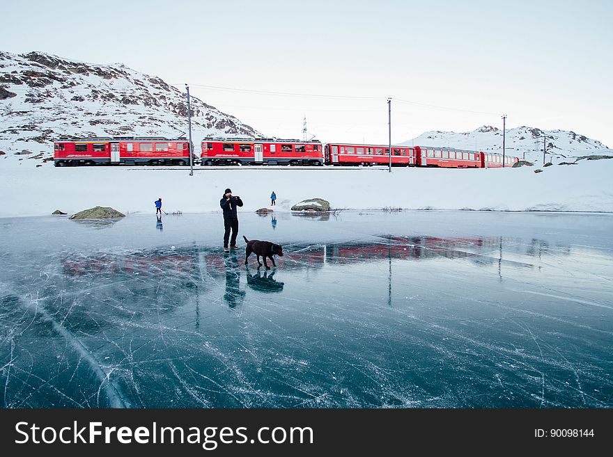 Person walking dog on frozen lake