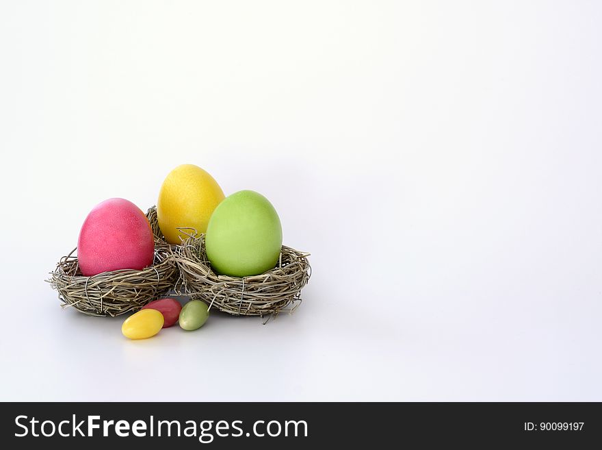 Colorful dyed Easter eggs in birds nests on white. Colorful dyed Easter eggs in birds nests on white.
