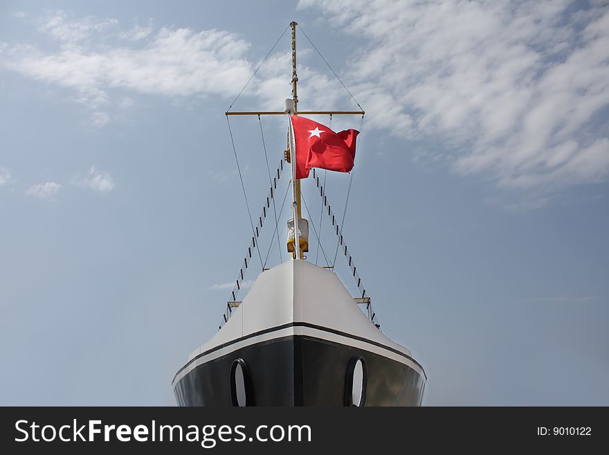 Front view of an old style ship with a flag
