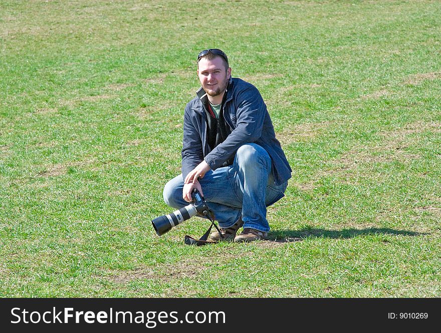 Man on meadow with camera. Man on meadow with camera