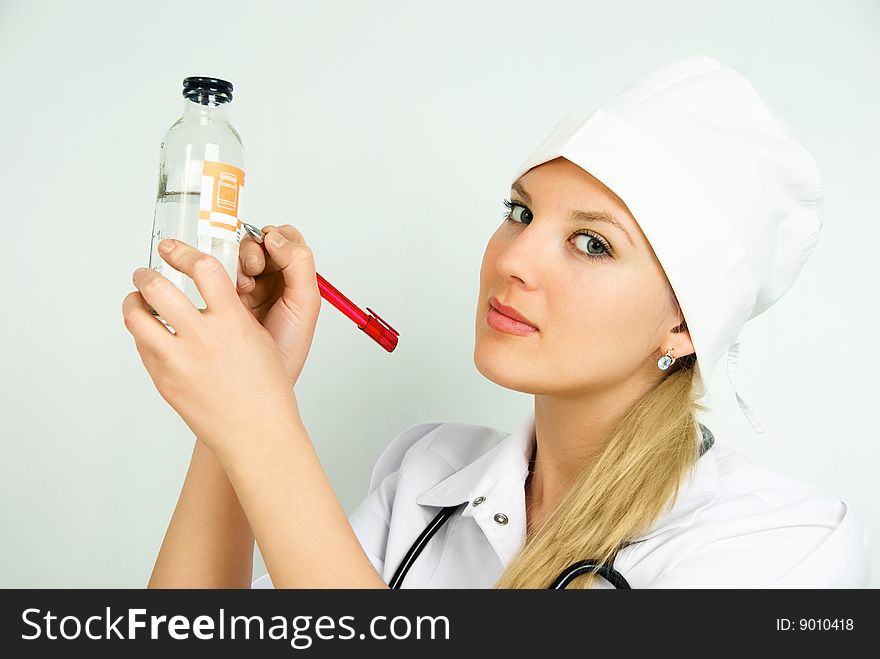 Portrait of a beautiful young doctor with a stethoscope and a bottle. Portrait of a beautiful young doctor with a stethoscope and a bottle