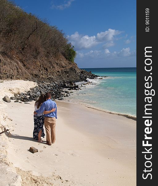 Couple standing on Frys beach on Antigua Barbuda in the Caribbean Lesser Antilles West Indies. Couple standing on Frys beach on Antigua Barbuda in the Caribbean Lesser Antilles West Indies.