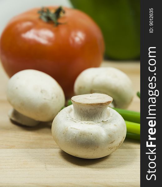 Fresh mushroom with tomato on the background. Fresh mushroom with tomato on the background