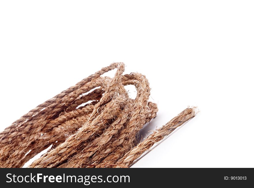 A horizontal tilted view of a coil of rope on white