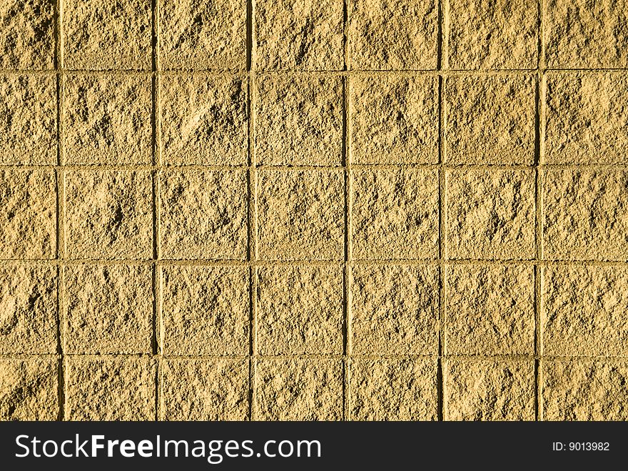 A stone wall is texture to look like rough tiles in the sun. A stone wall is texture to look like rough tiles in the sun.