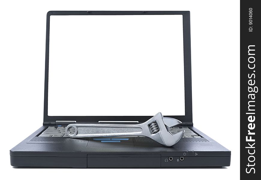A spanner over a black laptop isolated over white background. White copy space on screen. A spanner over a black laptop isolated over white background. White copy space on screen.