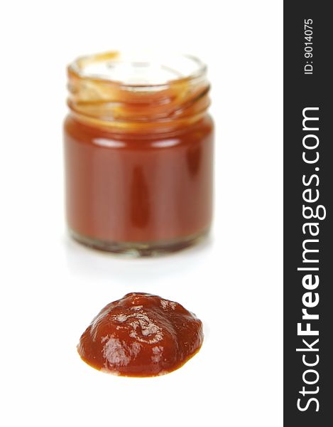 A small jar of ketchup isolated against a white background
