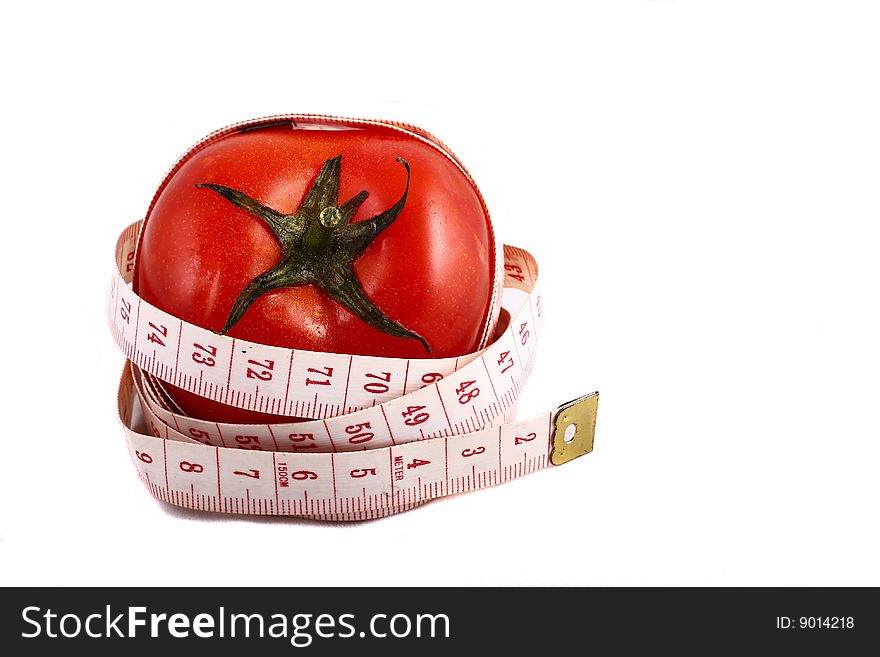 A tomato wrapped up by measuring tape. A tomato wrapped up by measuring tape