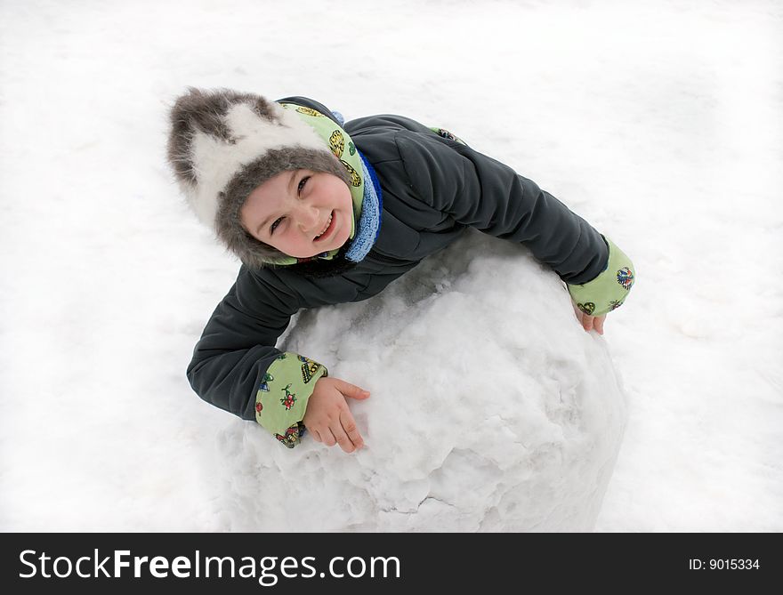 The girl in the winter on white snow with the big snow sphere. The girl in the winter on white snow with the big snow sphere