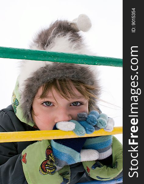 Portrait of the girl in the winter on a multi-coloured ladder