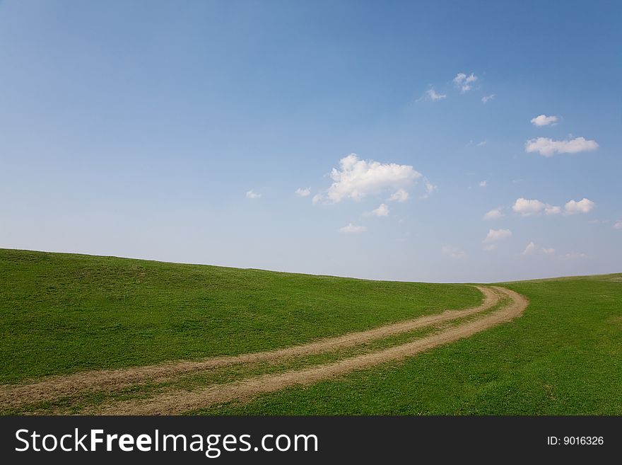 Narrow country road in a rural area on field