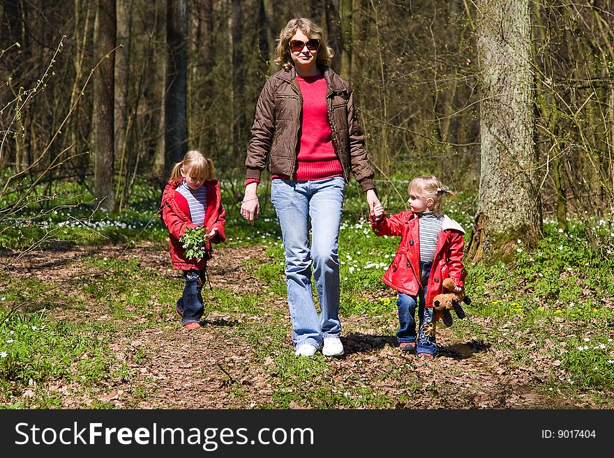 Mother running along woodland path with 2 children. Mother running along woodland path with 2 children