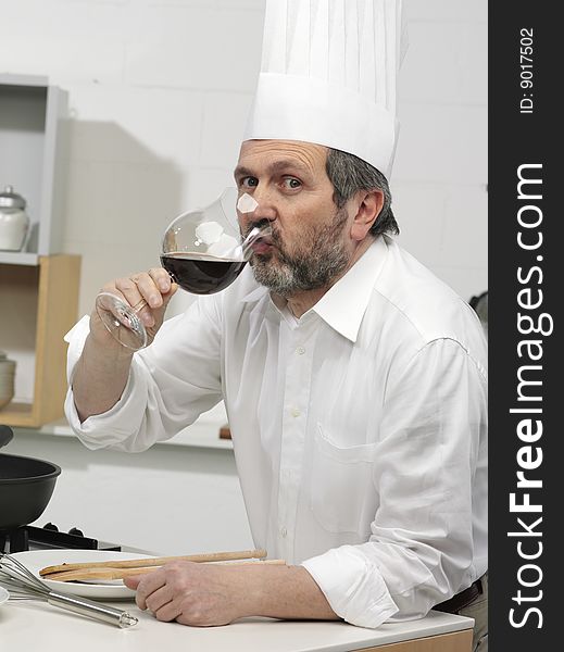 Cook in the kitchen with glass of wine