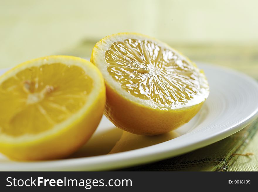 Two fresh lemon on white plate