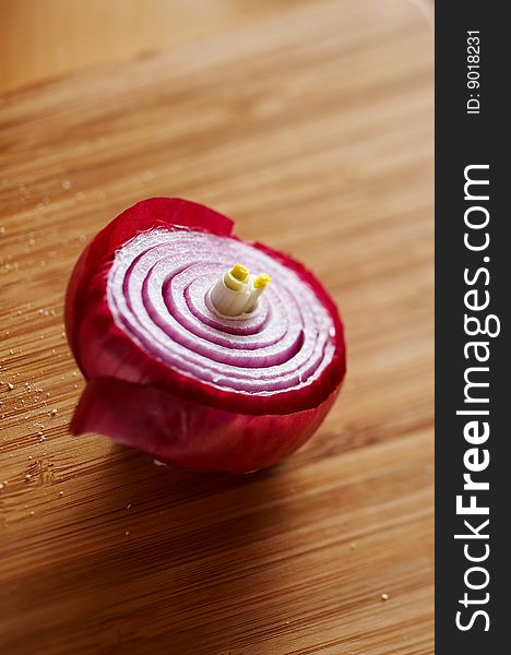 Detail of red onion on wooden desk