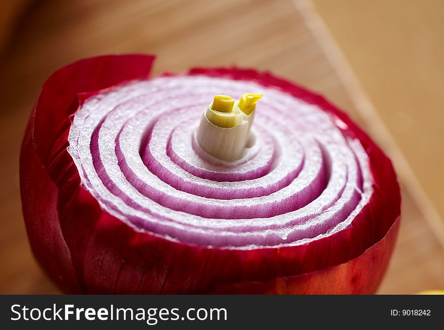 Detail of red onion on wooden desk