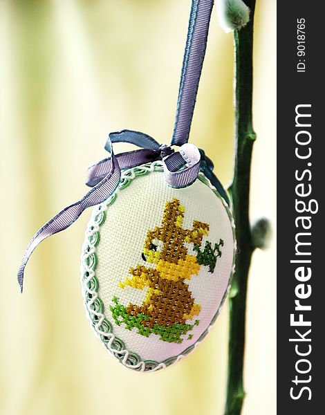 A egg is hanging on a plant, it is a decoration for easter. A egg is hanging on a plant, it is a decoration for easter
