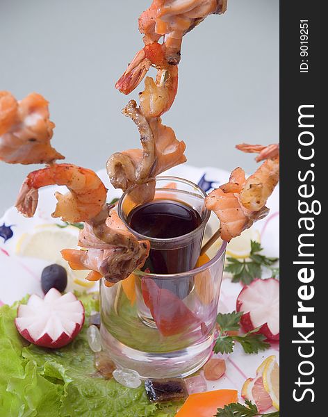 Snack from shrimps with sauce and vegetables