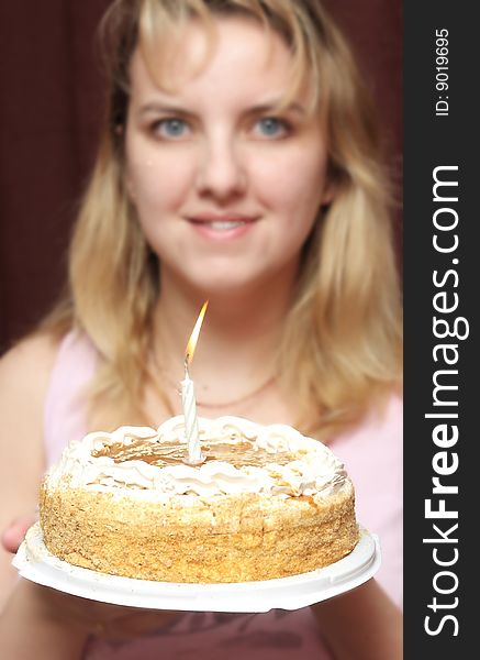 Pie with a candle in hands of the girl