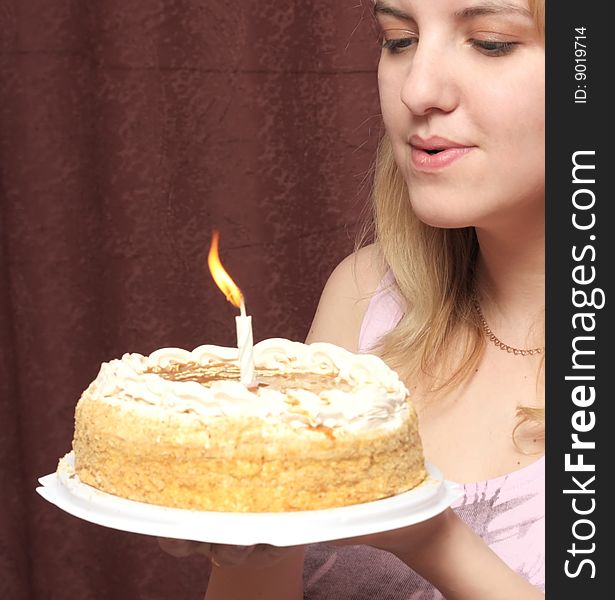 Girl blows on a candle on a pie