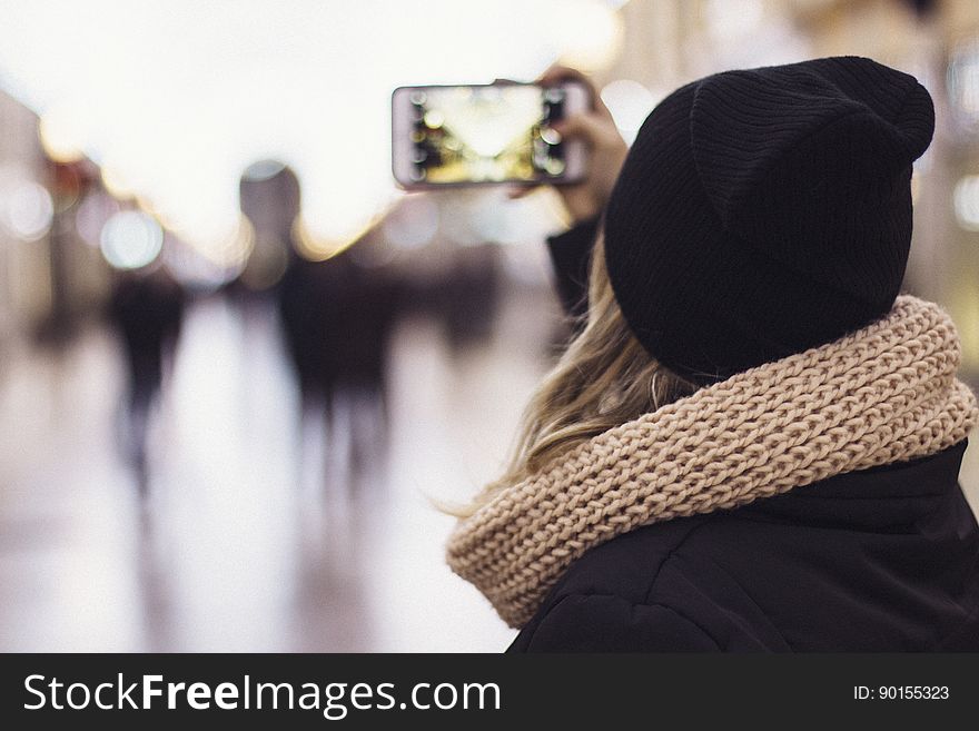 A woman snapping a photo with a smartphone camera. A woman snapping a photo with a smartphone camera.