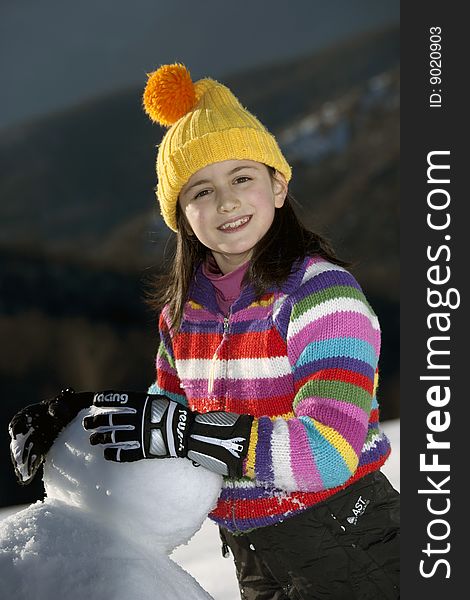 Young girl posing with her snowman