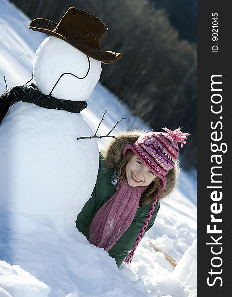 Young Girl Posing With Her Snowman