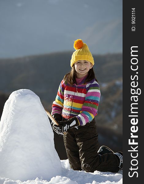 A cute young girl posing with her snowman