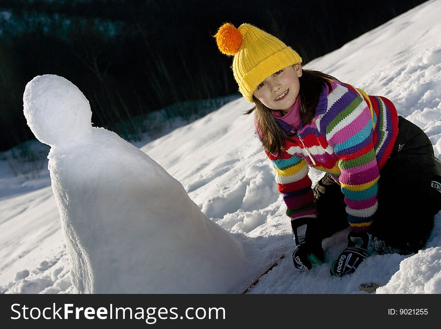 Young Girl Posing With Her Snowman