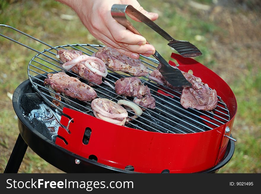 Spoon taking a slice of grilled meat. Spoon taking a slice of grilled meat