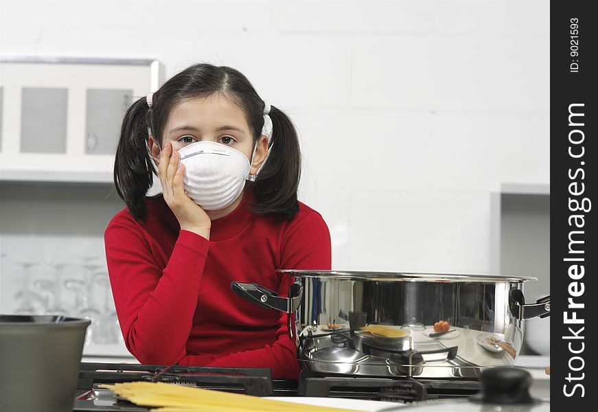 Little girl in the kitchen with mask