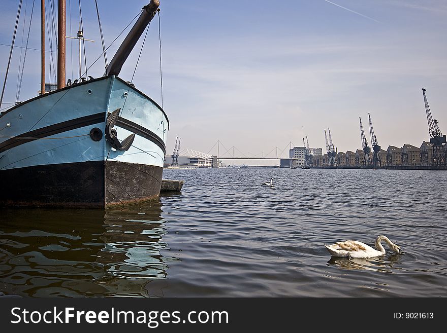 Boat in the harbour with swans and crane views. Boat in the harbour with swans and crane views