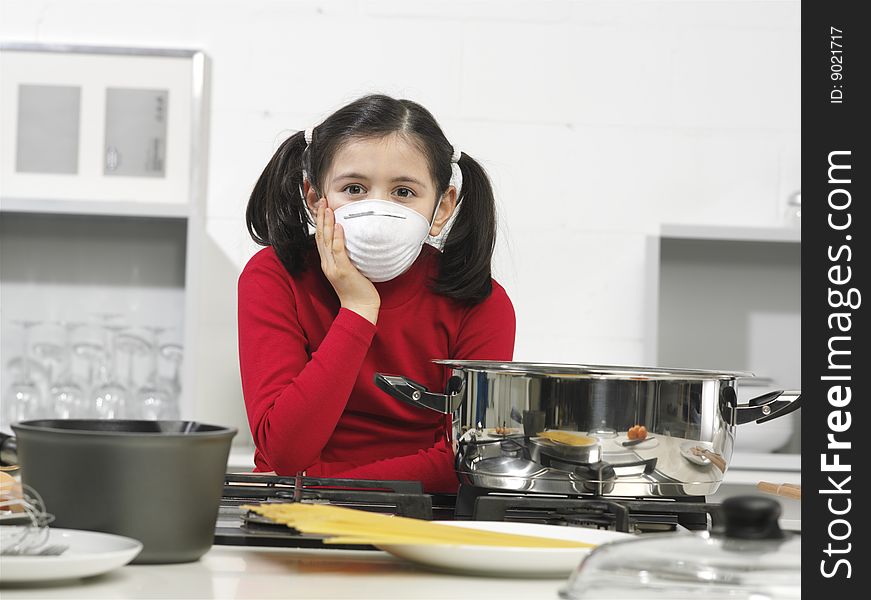 Little girl in the kitchen with mask