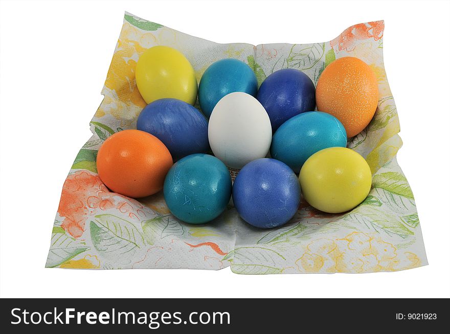 Multi-coloured Easter eggs lay on a napkin of a spring ornament