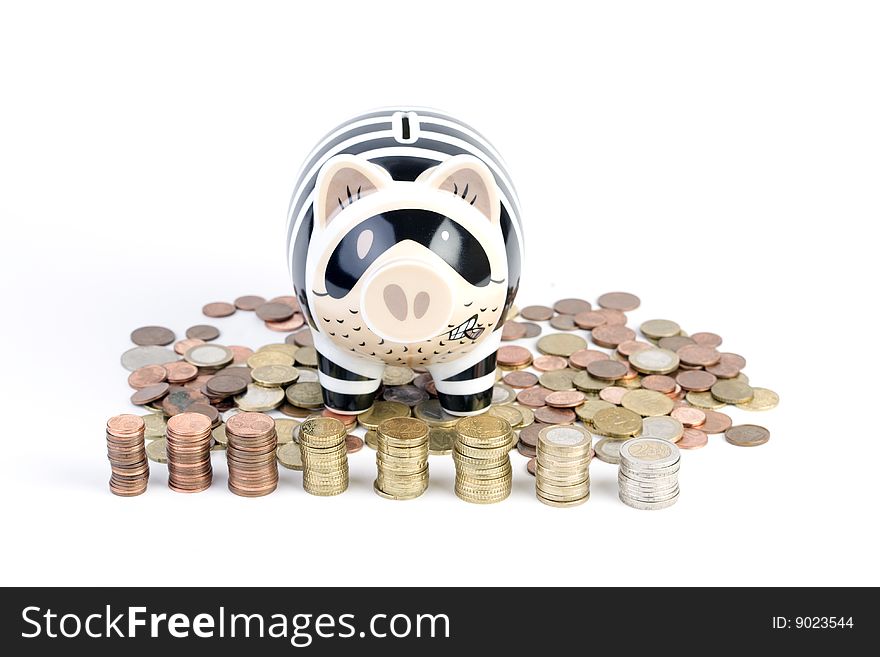 Closeup of a piggy bank sitting on euro coins