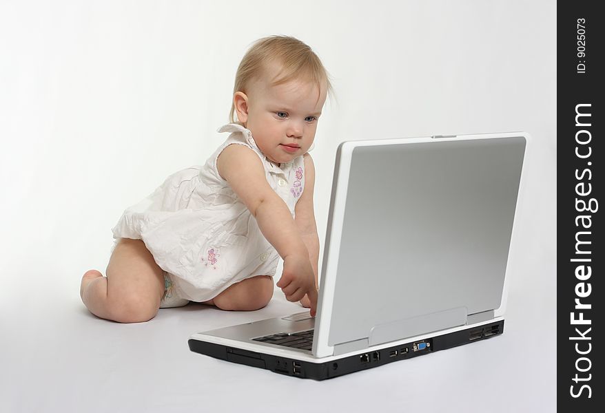 Little girl pressing the button on the laptop