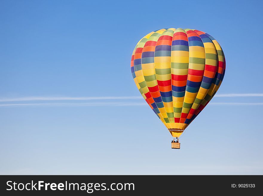 Unrecognizable people travelling in a multicolor balloon. Unrecognizable people travelling in a multicolor balloon