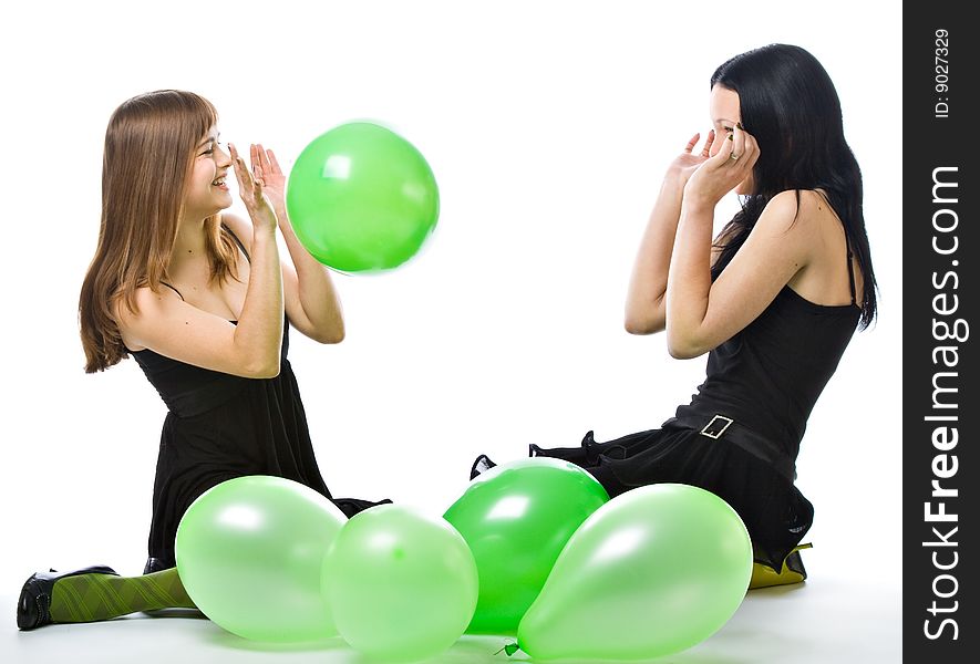 Two young girls with green ballons