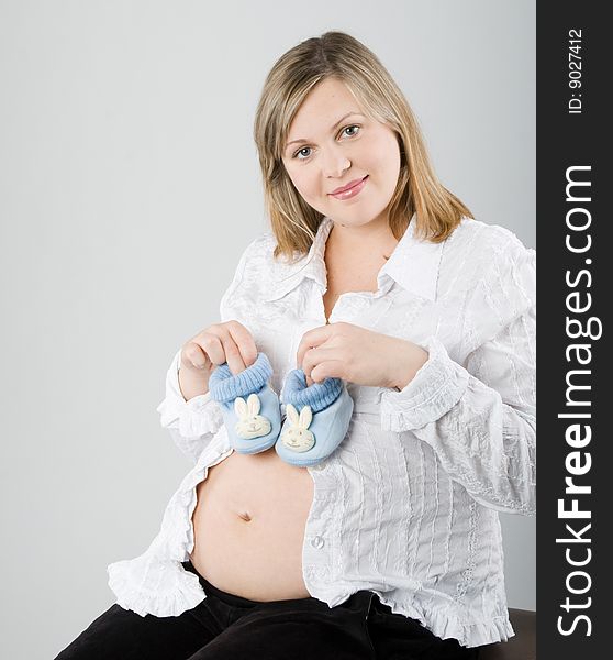 The pregnant woman on a gray background