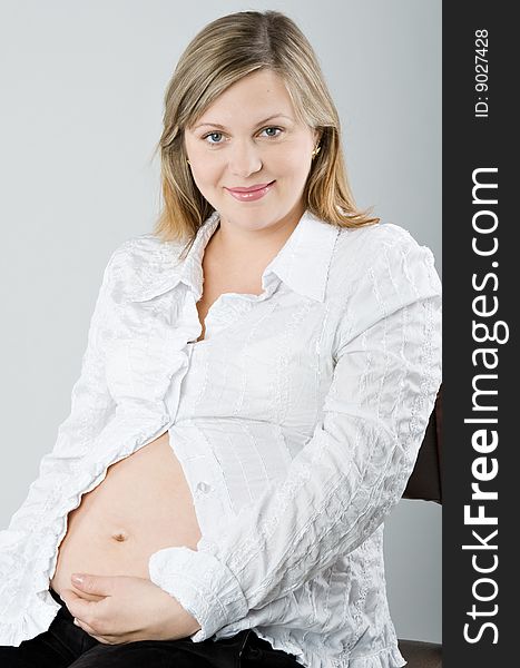The pregnant woman on a gray background