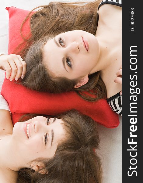 Two girls lying on red pillow