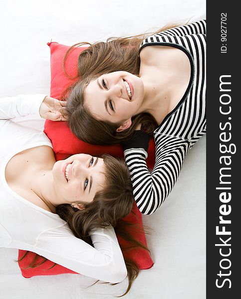 Two girls lying on red pillow