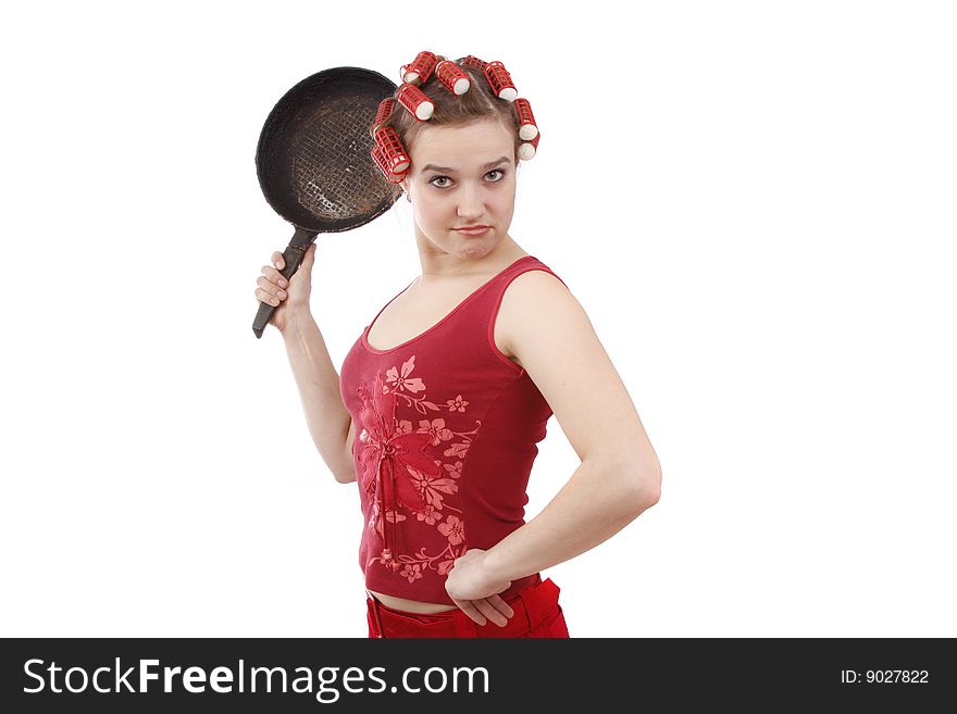 Portrait of a young angry girl with hair rollers and frying pan. Portrait of a young angry girl with hair rollers and frying pan.