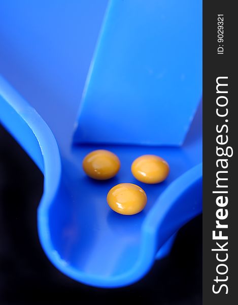 Three tablets on a blue pill counter with selective focus