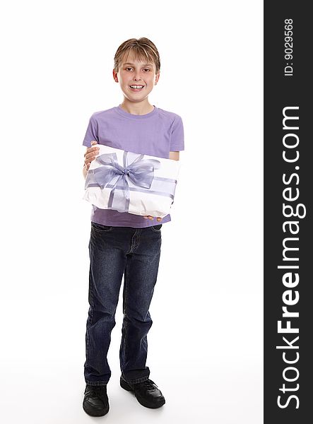 A boy smiles with a wrapped present tied up with big ribbon bow. A boy smiles with a wrapped present tied up with big ribbon bow