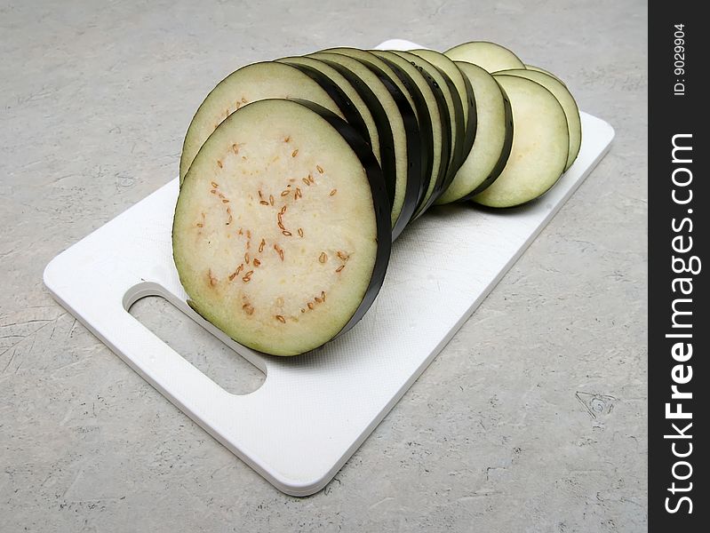 Cutted eggplant on the white knife board.