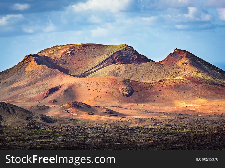 Desert landscape with sand dunes and rocky hills.