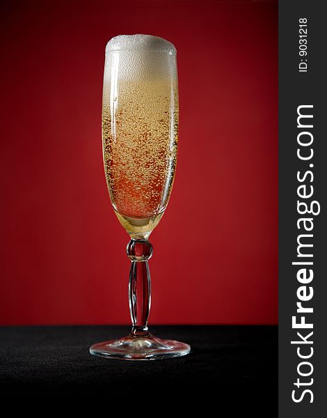Champagne glass over red background