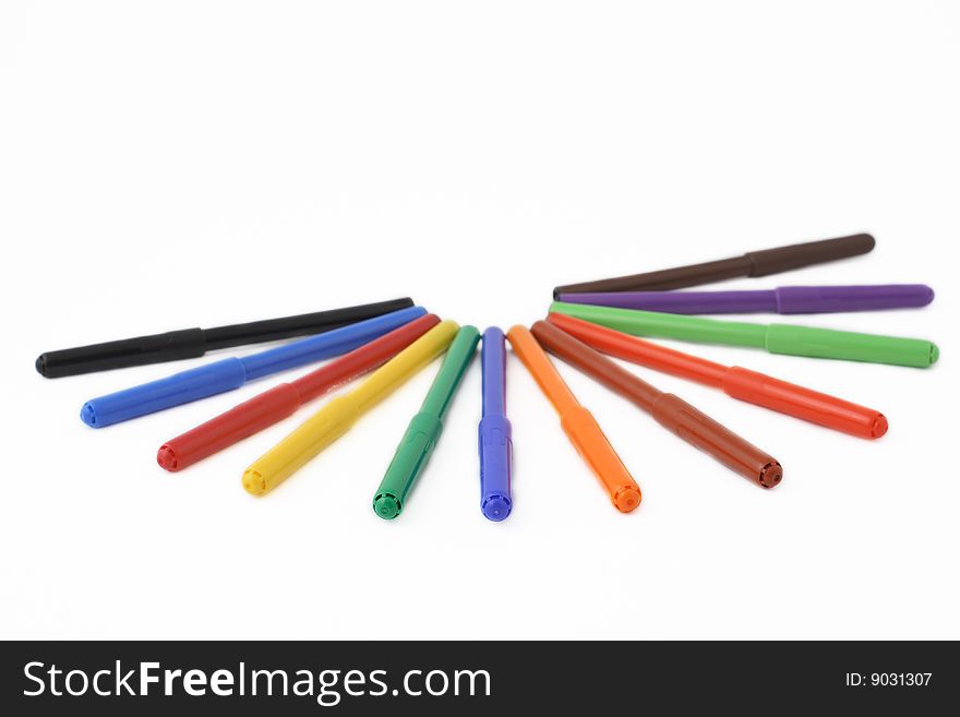 Multicolored felt tip pens over white background